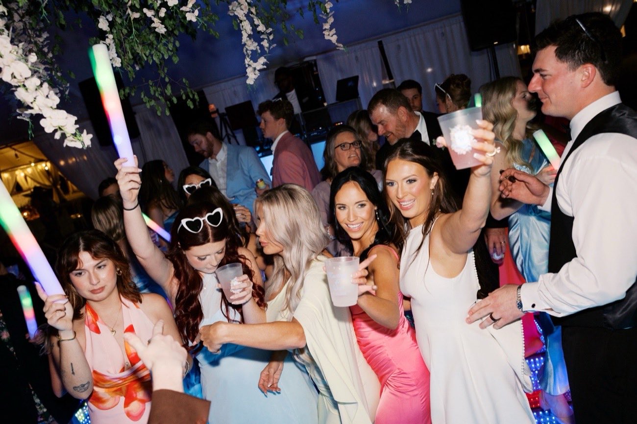 Bridesmaids celebrating with personalized wedding cups on the dance floor