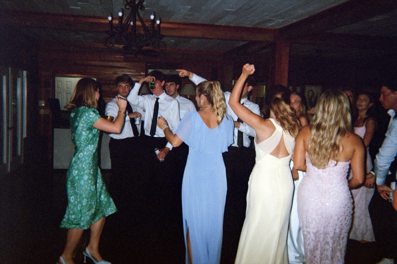Wedding guests dancing in a circle, arms raised