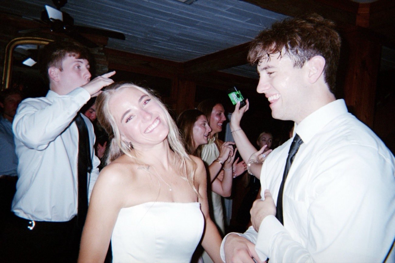 Bride laughing with a groomsman on the dance floor