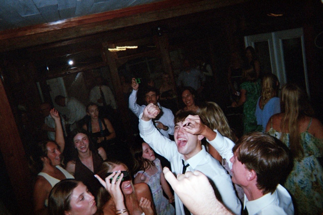 Guests cheering and dancing together at the reception