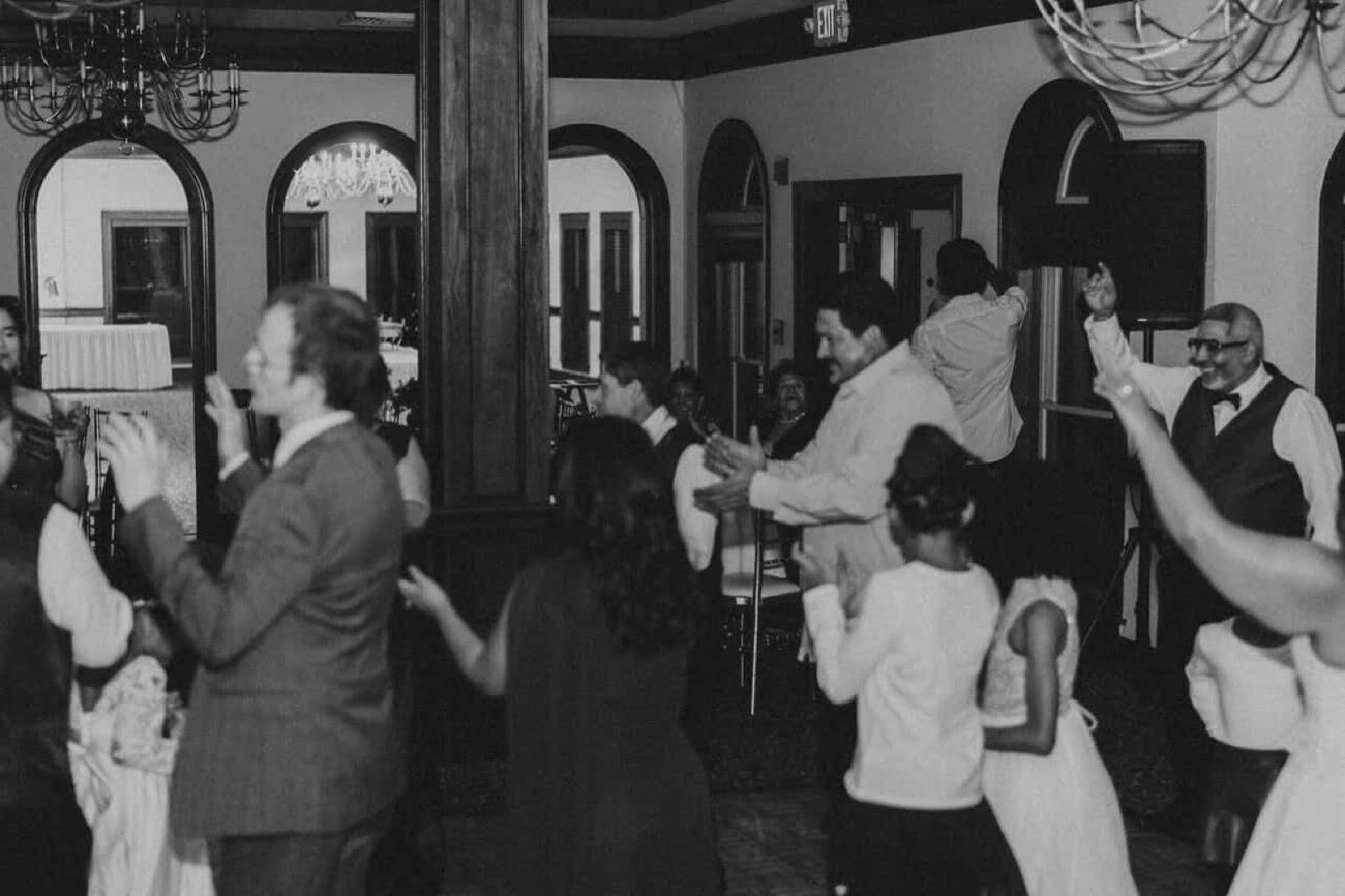 Multigenerational family and friends cheering together on the dance floor