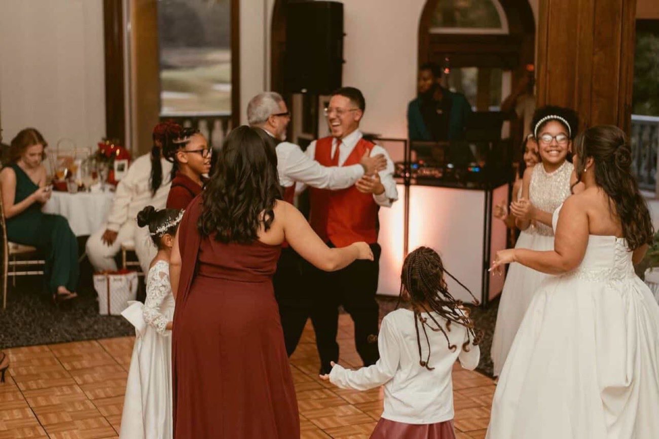 Multiple generations of a family dancing together at a fusion wedding reception